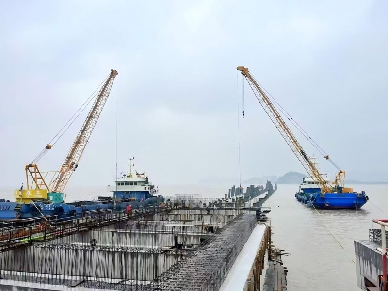 Two OUCO diesel-hydraulic lattice boom cranes operating in nearshore waters