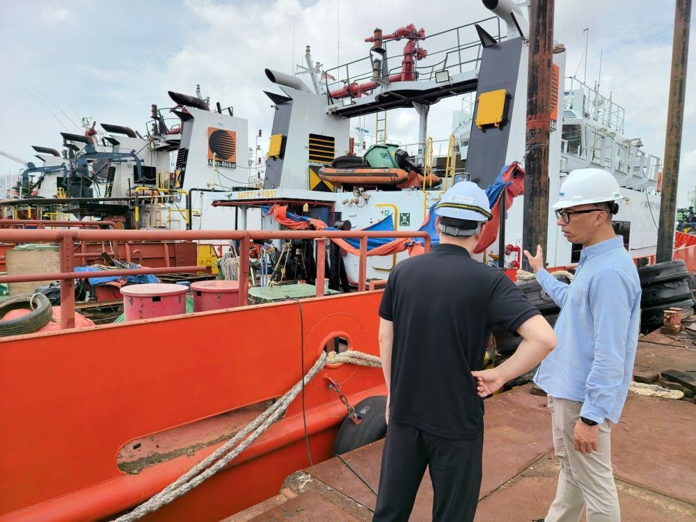 OUCO team discussing marine equipment solutions on vessel deck OUCO team discussing marine equipment solutions on vessel deck