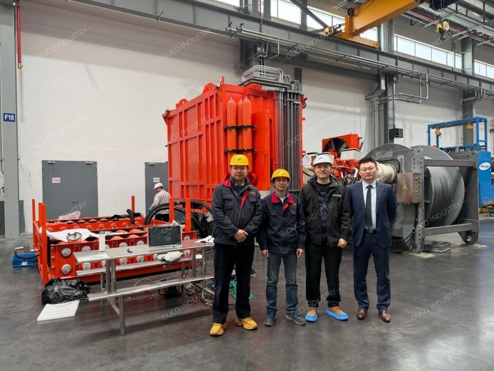 OUCO Group photo in front of large-scale industrial testing equipment