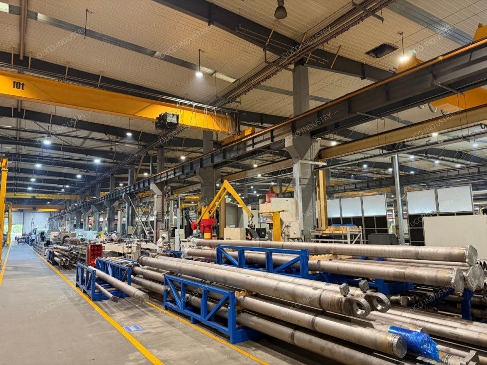 Heavy-duty hydraulic cylinders stored on racks in the workshop